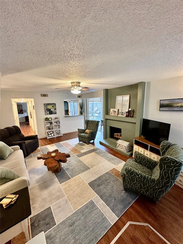 living room with ceiling fan and a textured ceiling