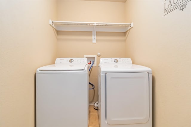 clothes washing area featuring washer and dryer and light tile patterned flooring