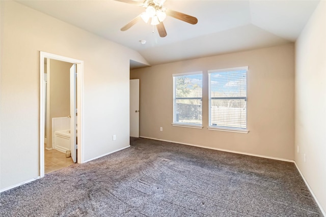 unfurnished bedroom featuring lofted ceiling, ensuite bath, ceiling fan, and carpet flooring