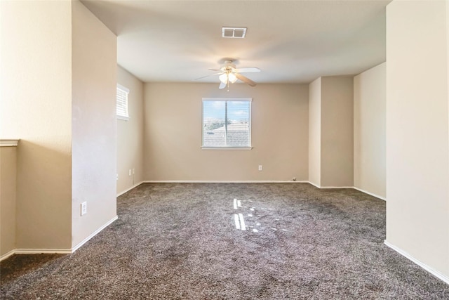 empty room with dark colored carpet and ceiling fan