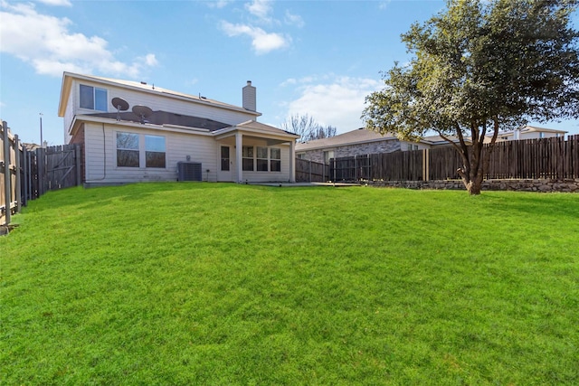 back of house featuring central AC and a lawn