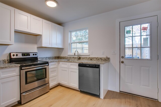 kitchen featuring white cabinets, sink, appliances with stainless steel finishes, light hardwood / wood-style floors, and light stone counters