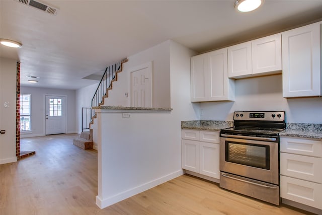 kitchen with white cabinets, light hardwood / wood-style floors, light stone counters, and stainless steel range with electric cooktop