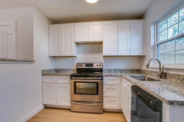 kitchen featuring light stone countertops, sink, black dishwasher, stainless steel electric stove, and white cabinets