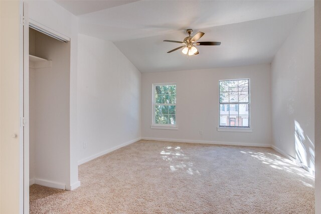 unfurnished bedroom with ceiling fan, light carpet, and lofted ceiling