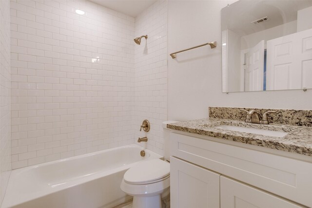 full bathroom with vanity, tiled shower / bath combo, and toilet