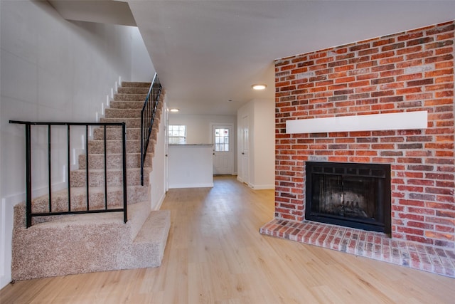 unfurnished living room featuring a fireplace and light hardwood / wood-style floors