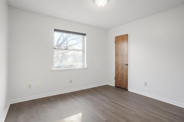 unfurnished room featuring a textured ceiling and dark hardwood / wood-style flooring