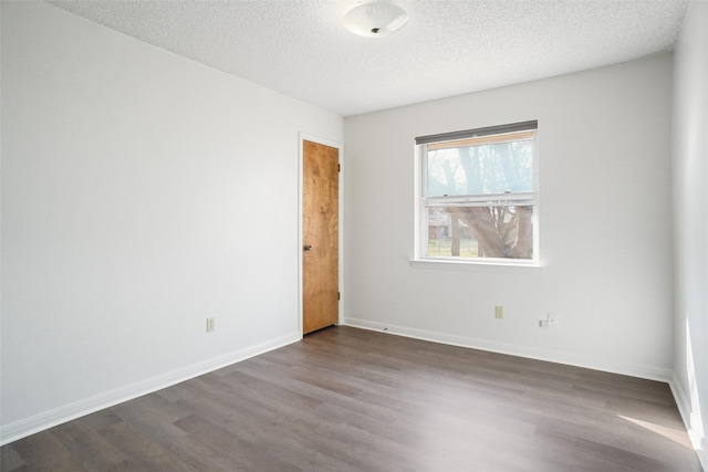 unfurnished room with hardwood / wood-style flooring and a textured ceiling