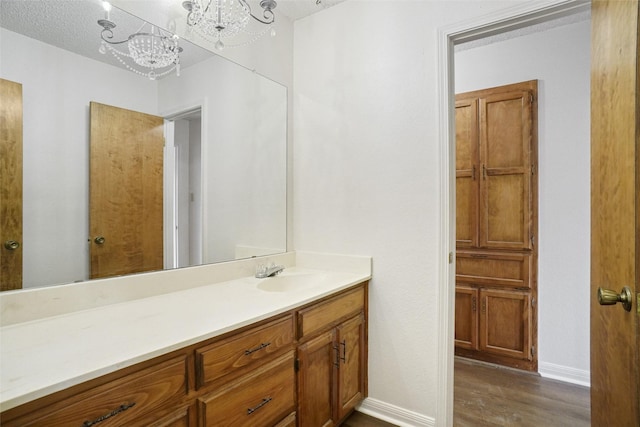 bathroom featuring a chandelier, hardwood / wood-style floors, and vanity