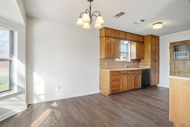 kitchen featuring sink, dishwasher, an inviting chandelier, pendant lighting, and decorative backsplash