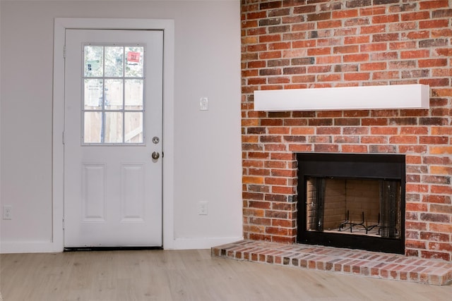 doorway to outside featuring light hardwood / wood-style floors and a fireplace