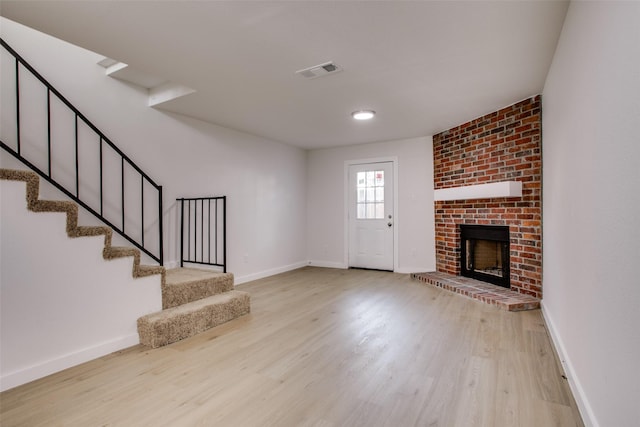 unfurnished living room featuring a fireplace and light hardwood / wood-style flooring