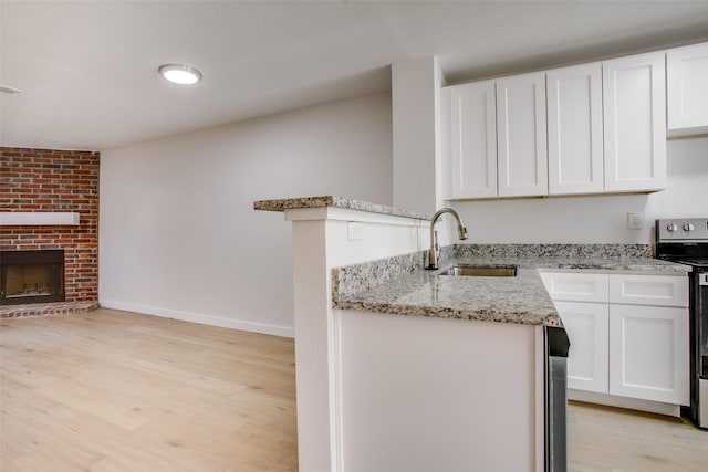 kitchen with white cabinetry, sink, stainless steel electric range, and light wood-type flooring