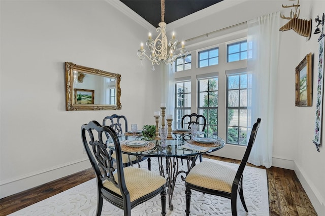 dining area featuring hardwood / wood-style floors, a chandelier, a high ceiling, and ornamental molding