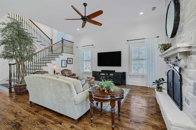 living room featuring a fireplace, ceiling fan, and dark hardwood / wood-style flooring