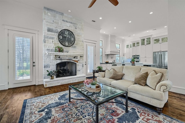 living room featuring a fireplace, dark hardwood / wood-style floors, a wealth of natural light, and ceiling fan