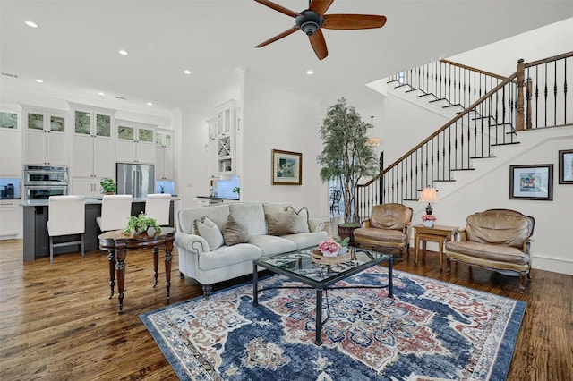 living room featuring dark hardwood / wood-style flooring, ceiling fan, and crown molding