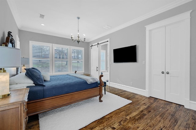 bedroom with a barn door, crown molding, dark hardwood / wood-style flooring, and a chandelier