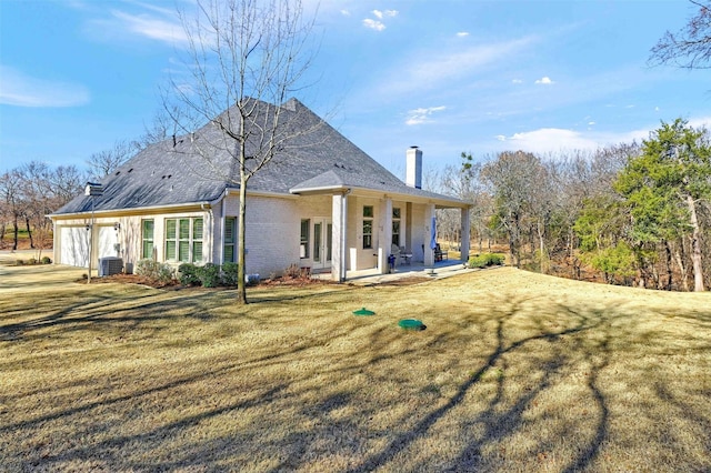 back of property with a lawn and central AC