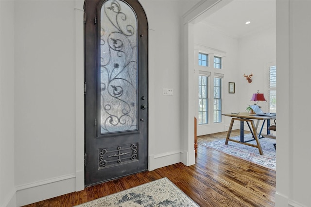 foyer entrance with dark hardwood / wood-style floors and ornamental molding