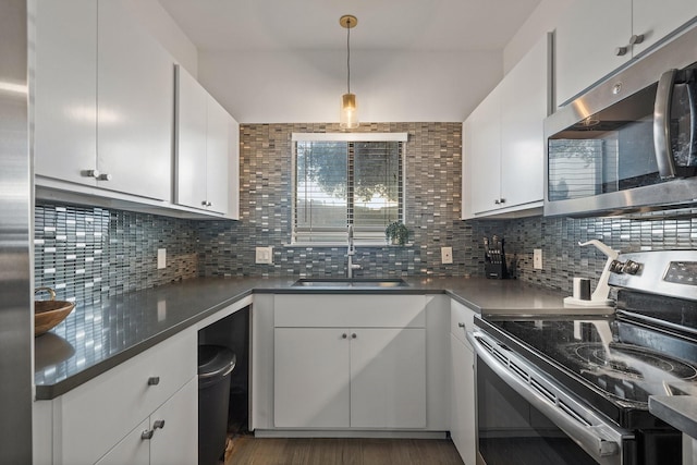 kitchen with white cabinets, appliances with stainless steel finishes, backsplash, and sink