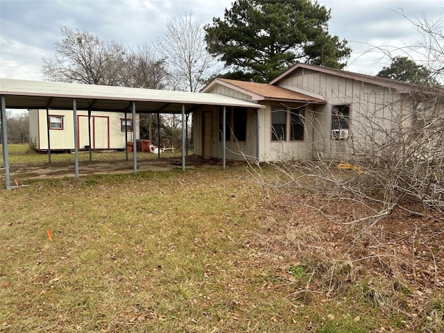 back of property featuring a lawn and a carport