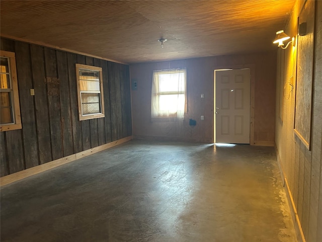 unfurnished room featuring wooden ceiling and wooden walls