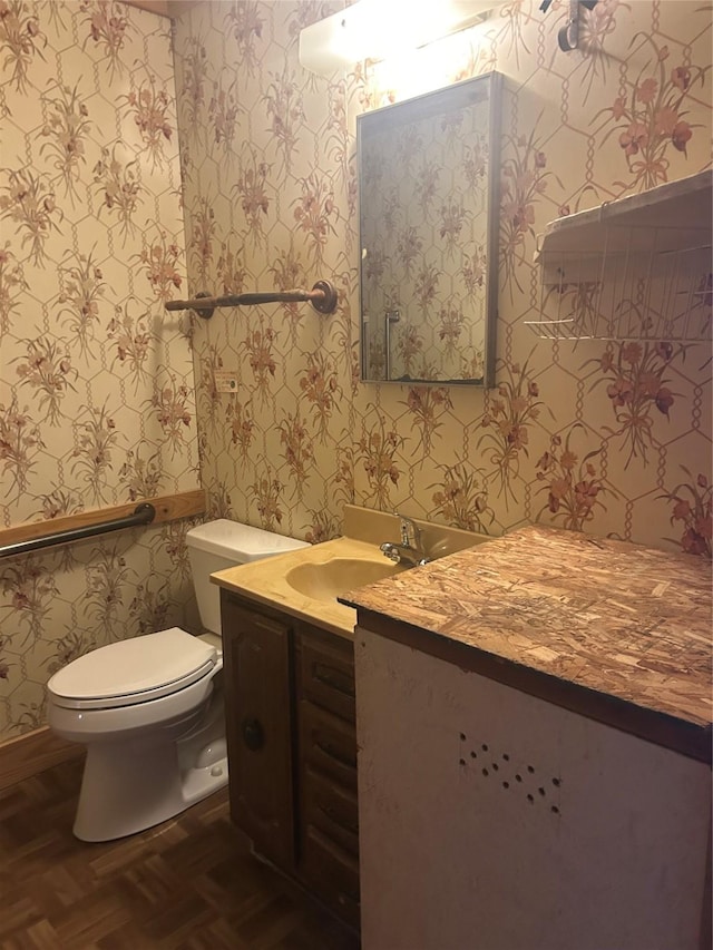 bathroom featuring vanity, parquet flooring, and toilet