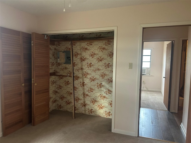 unfurnished bedroom featuring carpet flooring, cooling unit, electric panel, and a closet