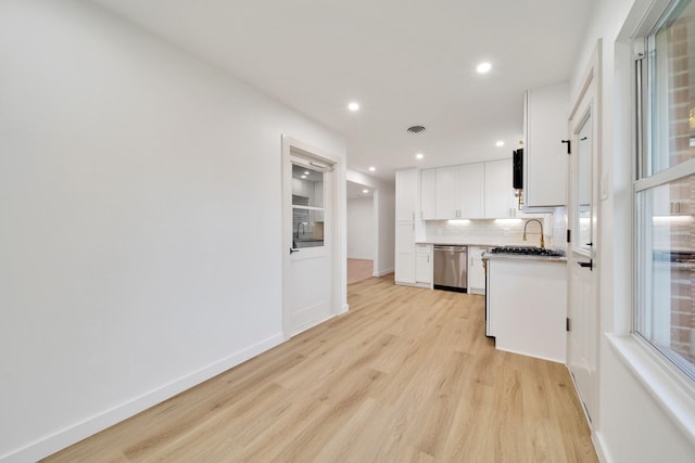 kitchen featuring backsplash, white cabinets, sink, light hardwood / wood-style flooring, and dishwasher