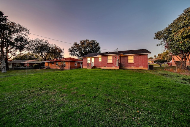 back house at dusk with a yard