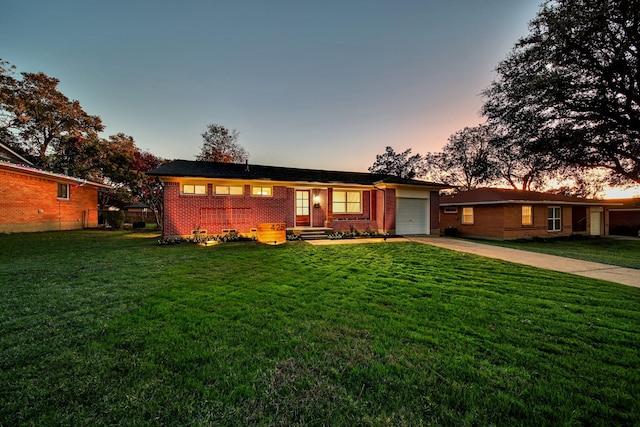 single story home with a garage and a yard