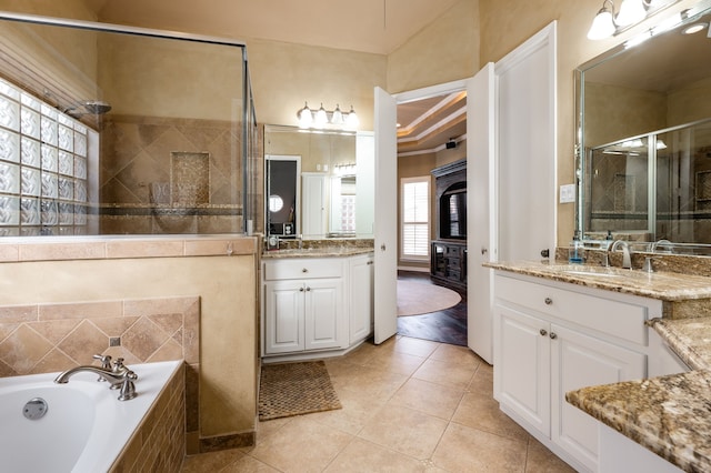 bathroom with vanity, a tray ceiling, ornamental molding, plus walk in shower, and tile patterned floors