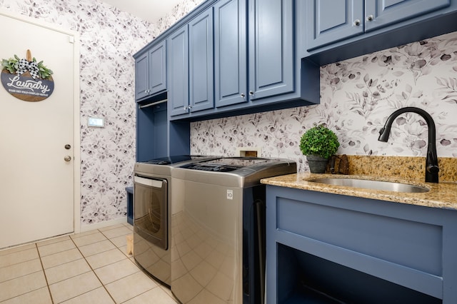 clothes washing area with cabinets, independent washer and dryer, sink, and light tile patterned floors