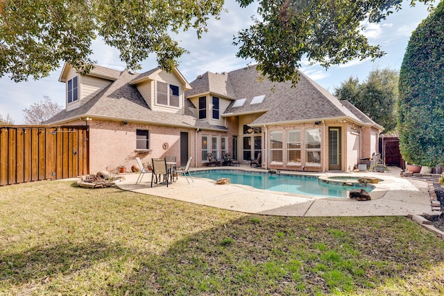 back of property featuring a lawn, a patio area, and a pool with hot tub