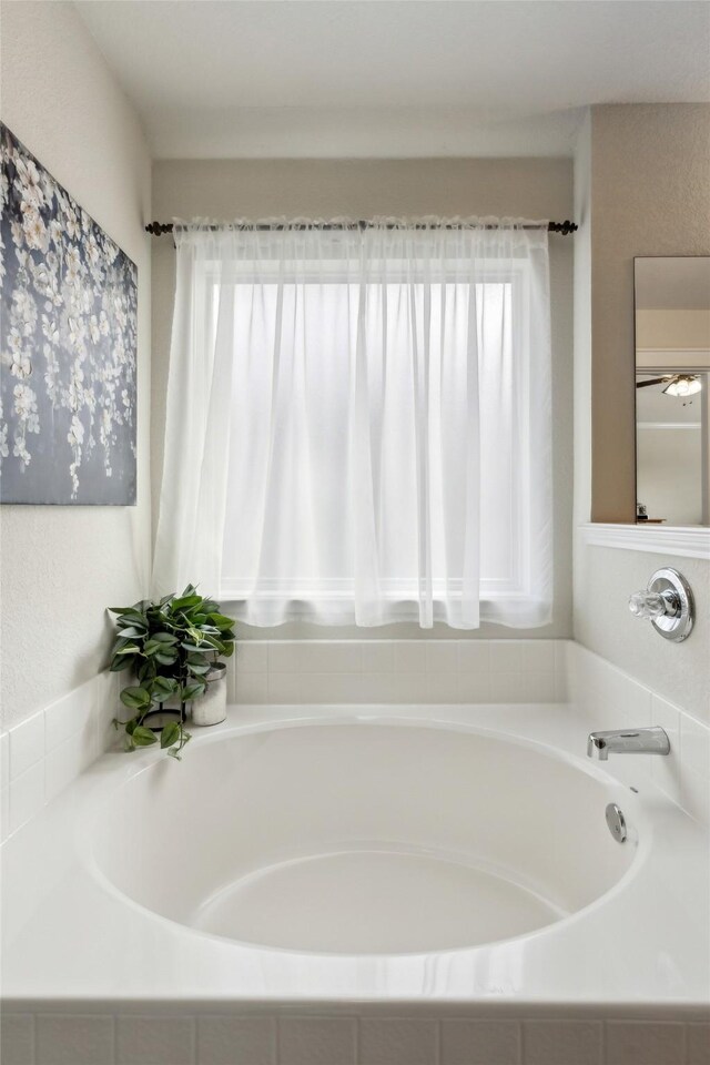 bathroom featuring a relaxing tiled tub