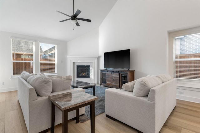 living room featuring ceiling fan, light hardwood / wood-style flooring, and high vaulted ceiling