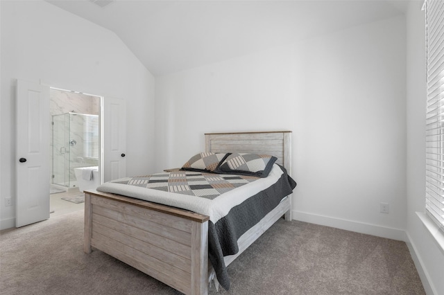 bedroom with ensuite bathroom, light colored carpet, and vaulted ceiling