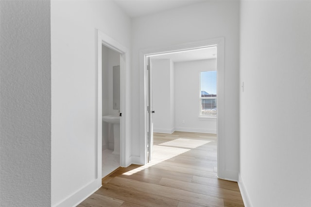 hallway with light hardwood / wood-style floors