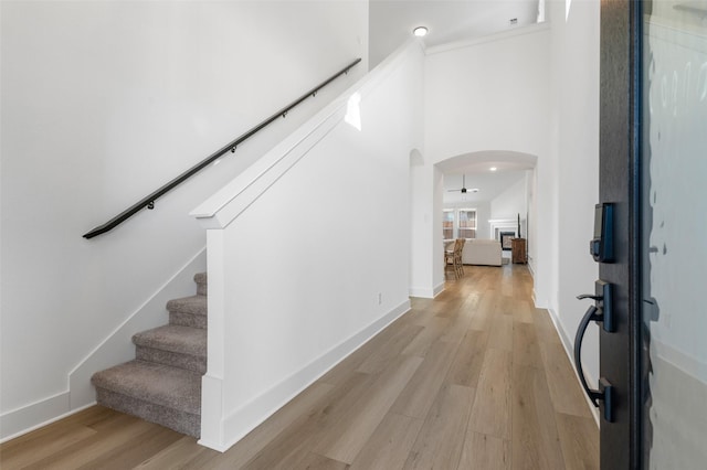 foyer entrance featuring a towering ceiling and light hardwood / wood-style flooring