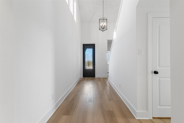 doorway featuring light hardwood / wood-style floors and a chandelier