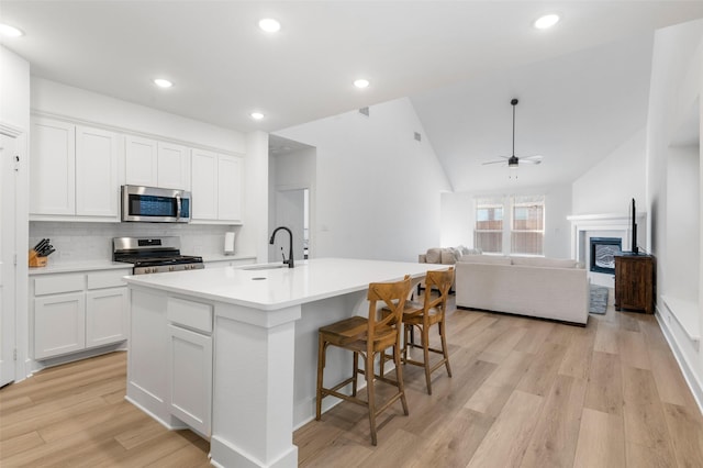 kitchen featuring white cabinetry, a kitchen island with sink, ceiling fan, and stainless steel appliances