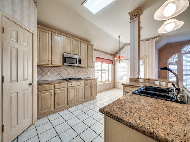 kitchen featuring pendant lighting, sink, appliances with stainless steel finishes, backsplash, and vaulted ceiling