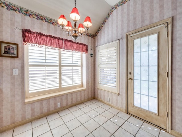 doorway to outside with tile patterned floors, vaulted ceiling, and a notable chandelier