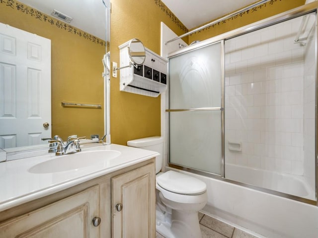 full bathroom featuring vanity, tile patterned flooring, toilet, and combined bath / shower with glass door