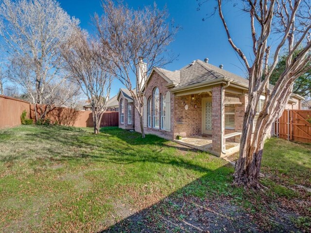 back of property featuring a yard and a patio