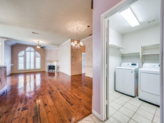 laundry area with washer and dryer, ceiling fan with notable chandelier, and light tile patterned floors