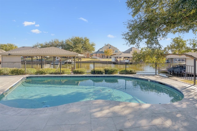 view of pool with a patio area and a water view