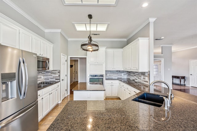 kitchen featuring sink, appliances with stainless steel finishes, white cabinetry, hanging light fixtures, and dark stone counters